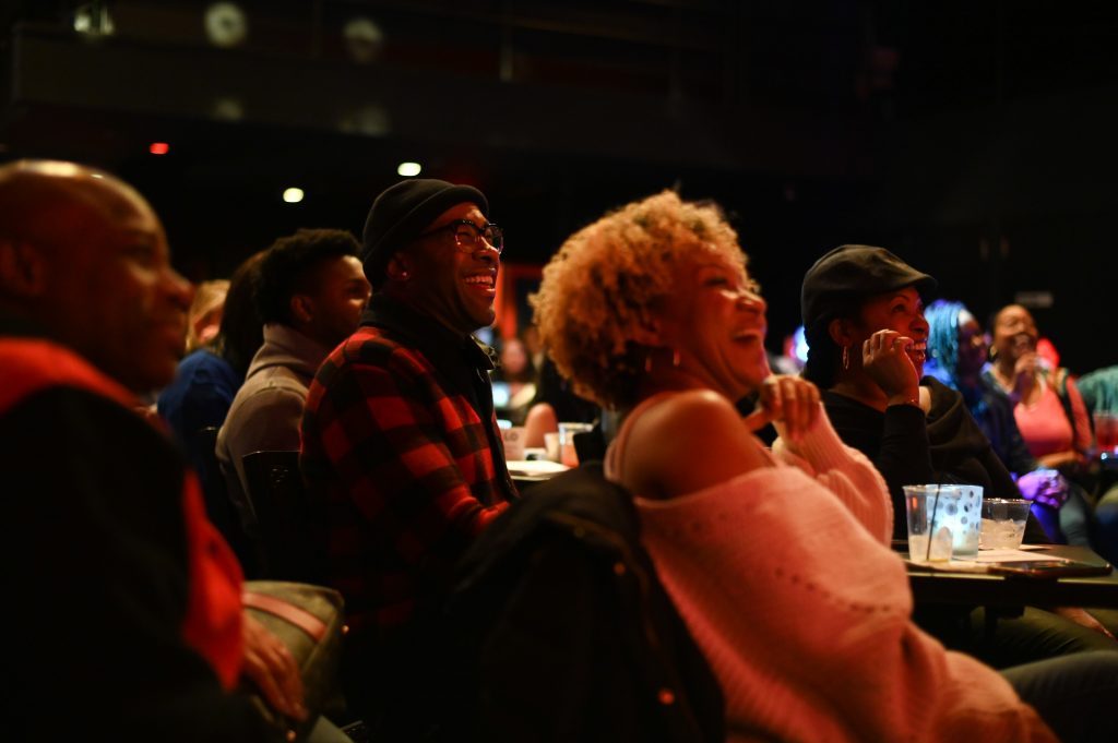 A group of people in the crowd at the Apollo Comedy Club