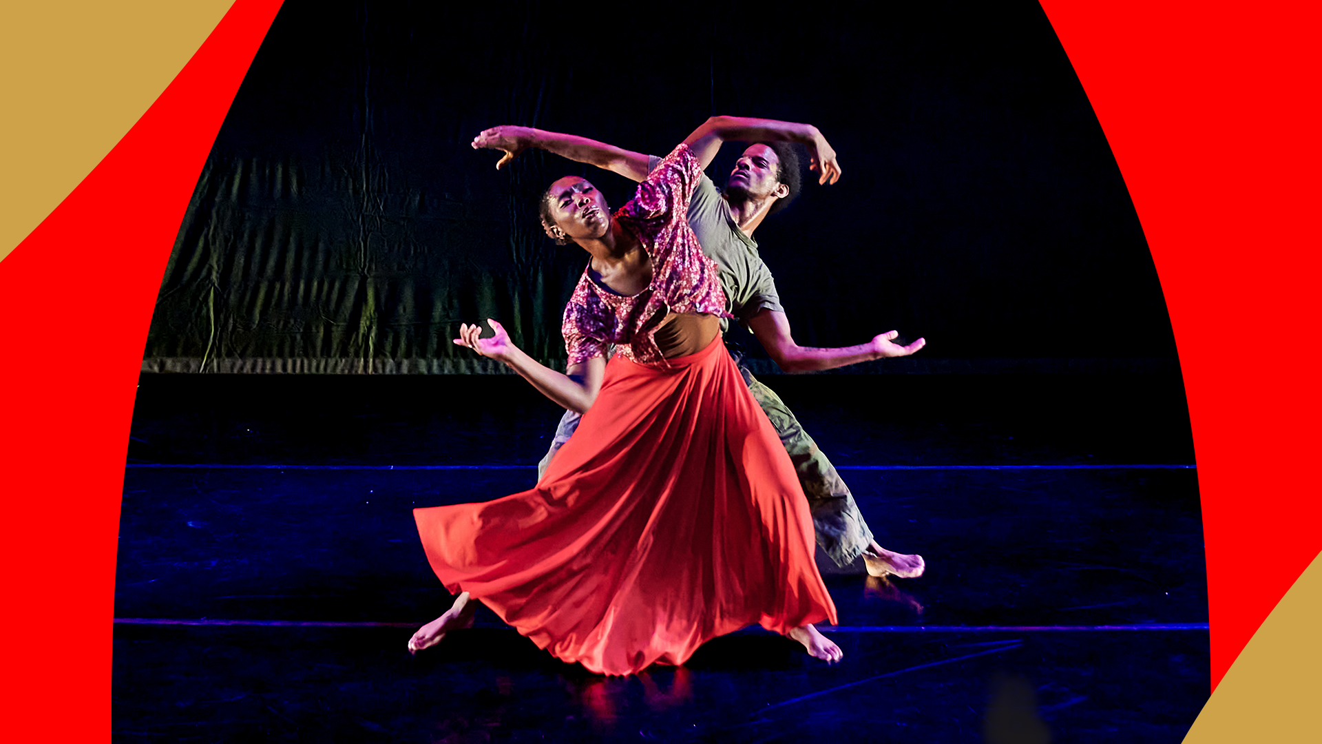 Two dancers of Creative Outlet moving in unison on stage.